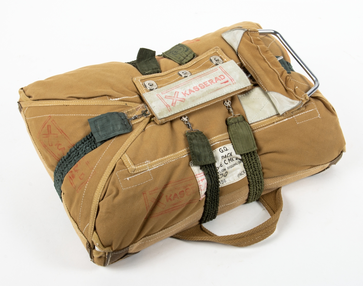 Bröstfallskärm, FASK 22. G.Q, Typ C. Mk.2.
Remmarnas utlösningsmekanism är helt mekanisk. Hölje av smärtingduk. Vit kalott av nylon. Skärmen är packad och stämplad Kasserad.
Medföljande sele med remmar av sadelgjord. Selen har individnumer 3834 och en etikett med texten; "Tillverkad av Irvin Fallskärmsaktiebolag Stockholm Sverige". (Osäkert om selen tillhör fallskärmen.)