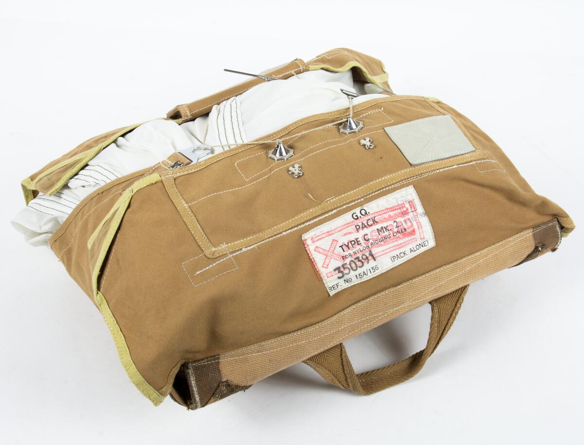 Bröstfallskärm, FASK 22. G.Q, Typ C. Mk.2.
Remmarnas utlösningsmekanism är helt mekanisk. Hölje av smärtingduk. Vit kalott av nylon. Skärmen är utlöst och stämplad Kasserad.
Medföljande tillhörande sele med remmar av sadelgjord.