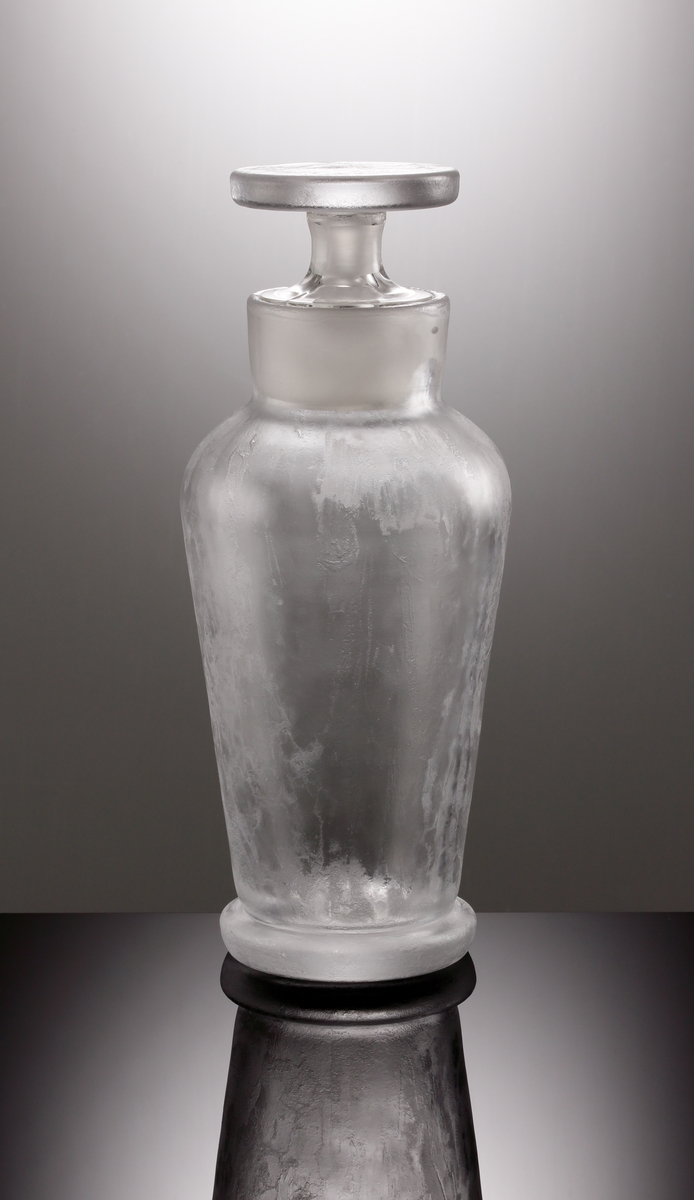 Formgiven av Vicke Lindstrand. Cocktailshaker med rund klackfot. Tillhörande issnipa och cylindrisk propp.
Isad yta.