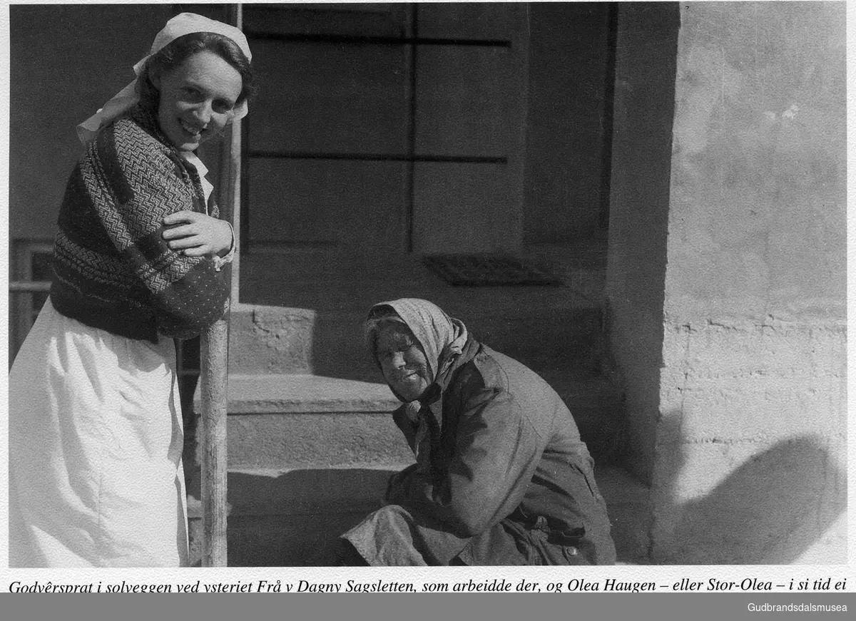 Godvêrsprat i solveggen ved ysteriet. Frå v Dagny Sagsletten, som arbeidde der, og Olea Haugen - eller Stor-Olea - i si tid ei markant dame i bybiletet. Her ventar ho på at ysterifolka skal koma ut att med fylt mjøkespann til henne.

Vågåkalenderen 1997, utgjevar: Vågå Kameraklubb