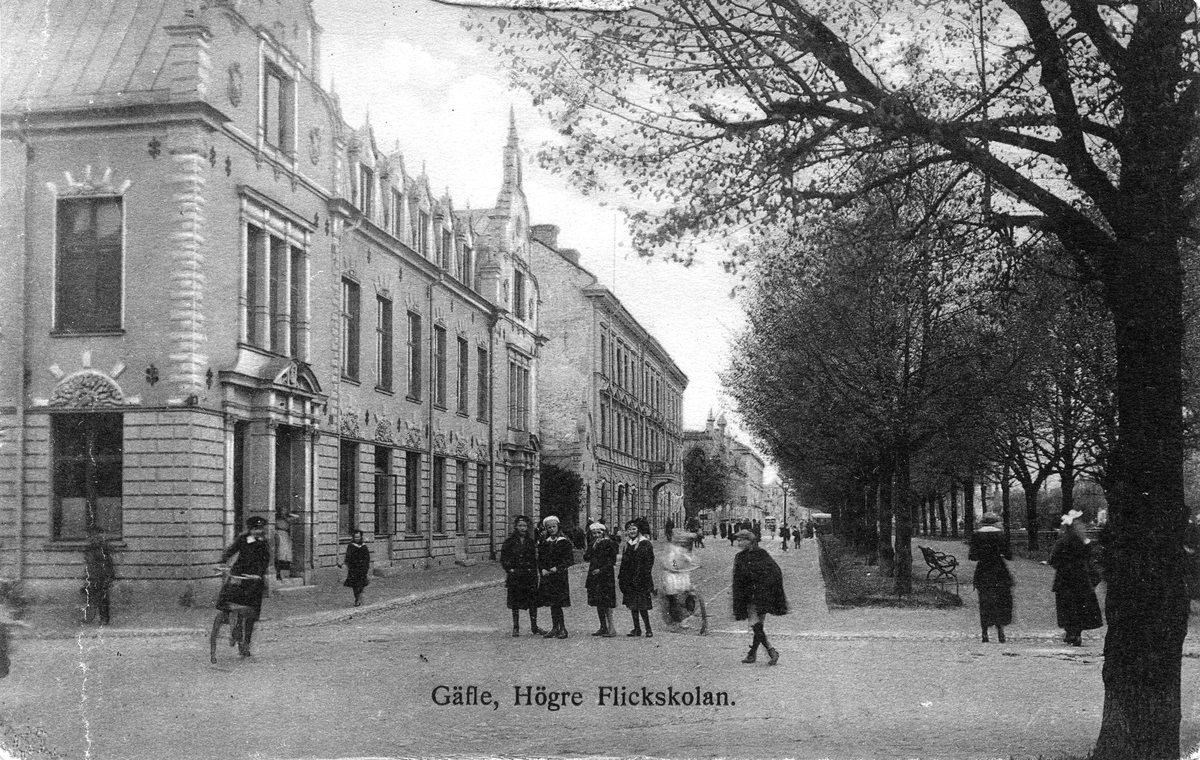 Gäfle, Högre Flickskolan. Text på vykortet "Här får du en välkänd bild från din barnsomsstad! Jag bor på Grand. Idag blåser hemskt här, men ännu ej regn. Ingeborg är sjuk, så dit kommer vi troligen ej. Hälsningar Ingrid. Till Fröken Ellen Lagerholm, Vanadisvägen 32 III, Stockholm". Skickat år 1918