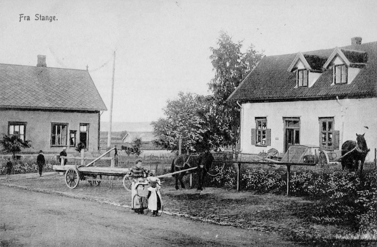 Postkort, Stange sentrum, Stangebyen, Storgata, kjøpmann Adolf Godagers forretningsgård Alfheim, til venstre Stange stasjon, folk i gata, hester med hestekjøretøy,