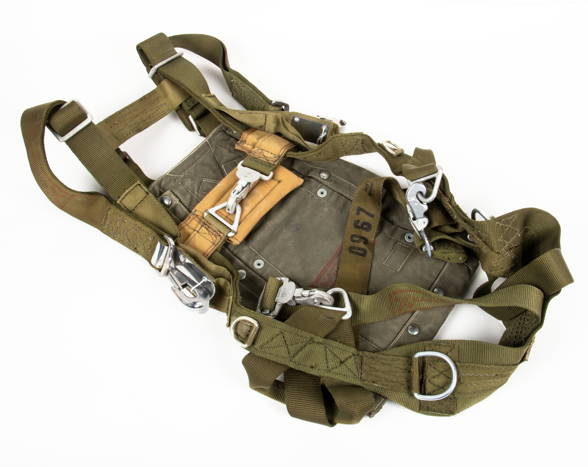 Fallskärm 23B, av bröstmodell. Fallskärm typ Irvin Parachute Assembly type RW 5/1 DRG No IAC 2693. Vit nylonkalott. Sele sadelgjord av nylon. Höljet av smärting. Bröstdel utgöres av skärmpacke.
Fallskärmen är utlöst.