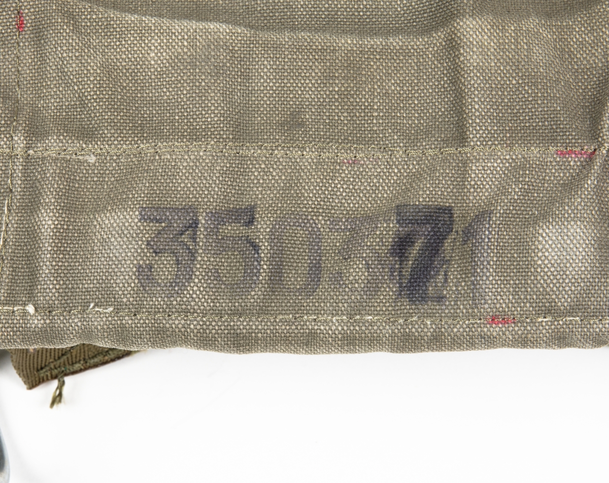 Fallskärm 23B, av bröstmodell. Fallskärm typ Irvin Parachute Assembly type RW 5/1 DRG No IAC 2693. Vit nylonkalott. Sele sadelgjord av nylon. Höljet av smärting. Bröstdel utgöres av skärmpacke.
Fallskärmen är utlöst.