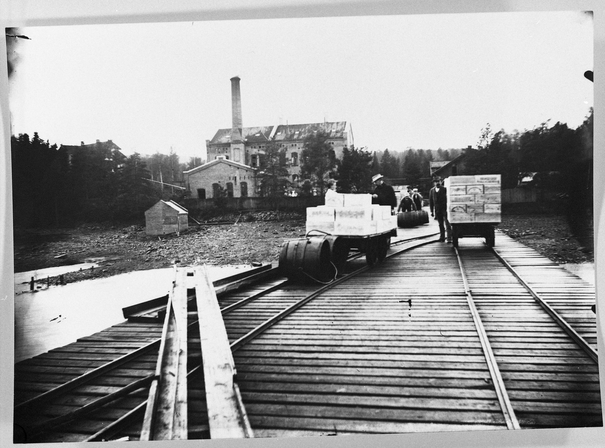 Den store dampskipsbrygga til mjølkefabrikken på Kapp med det første fabrikkanlegget i bakgrunnen. Året er ca. 1895. Øverst til venstre i bildet skimtes direktørboligen som brant sommeren 1945. Nr. to fra venstre i bildet er dr. Olsen (Sopp). De andre er ukjente.