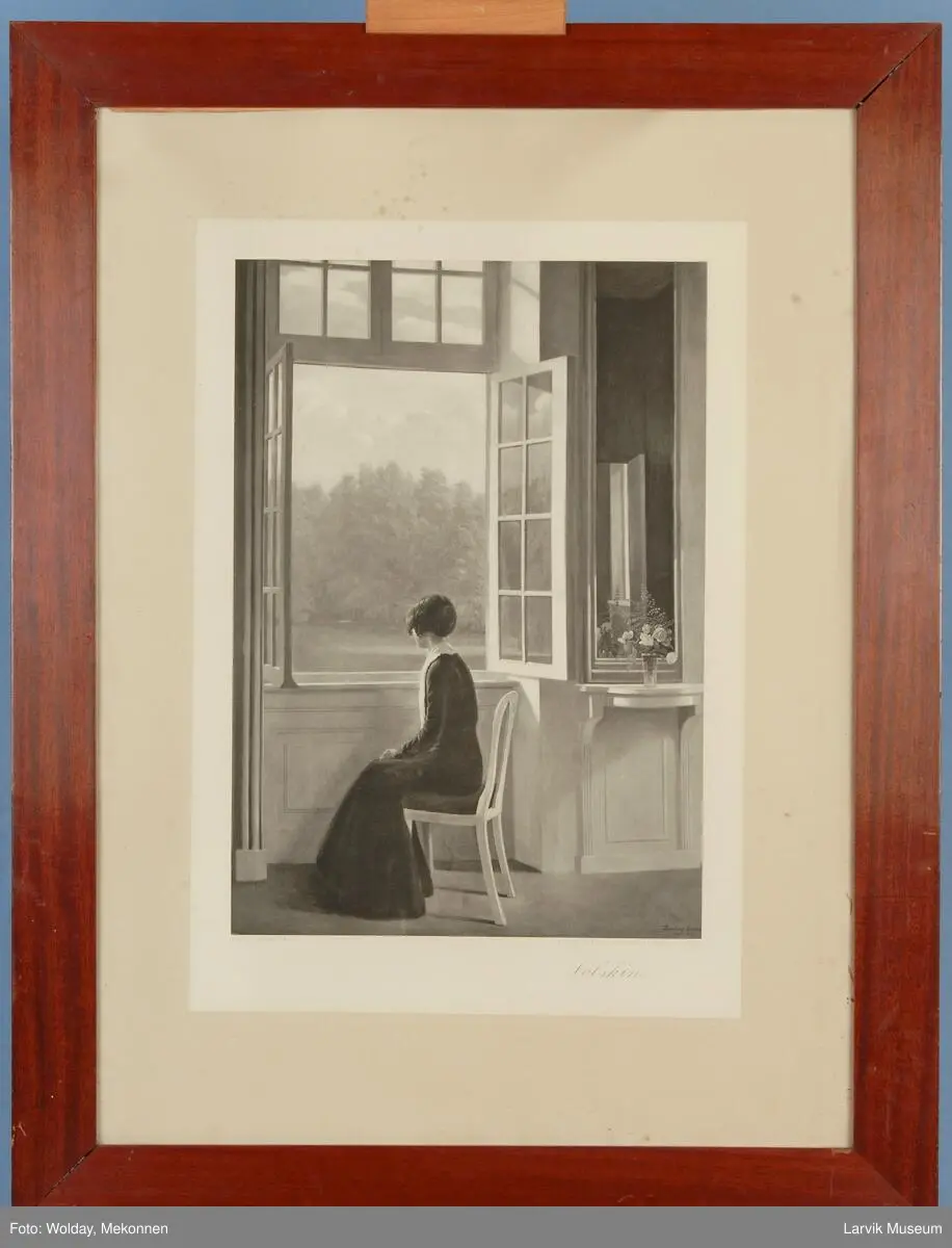 kvinne som sitter på en stol og ser ut av vindu