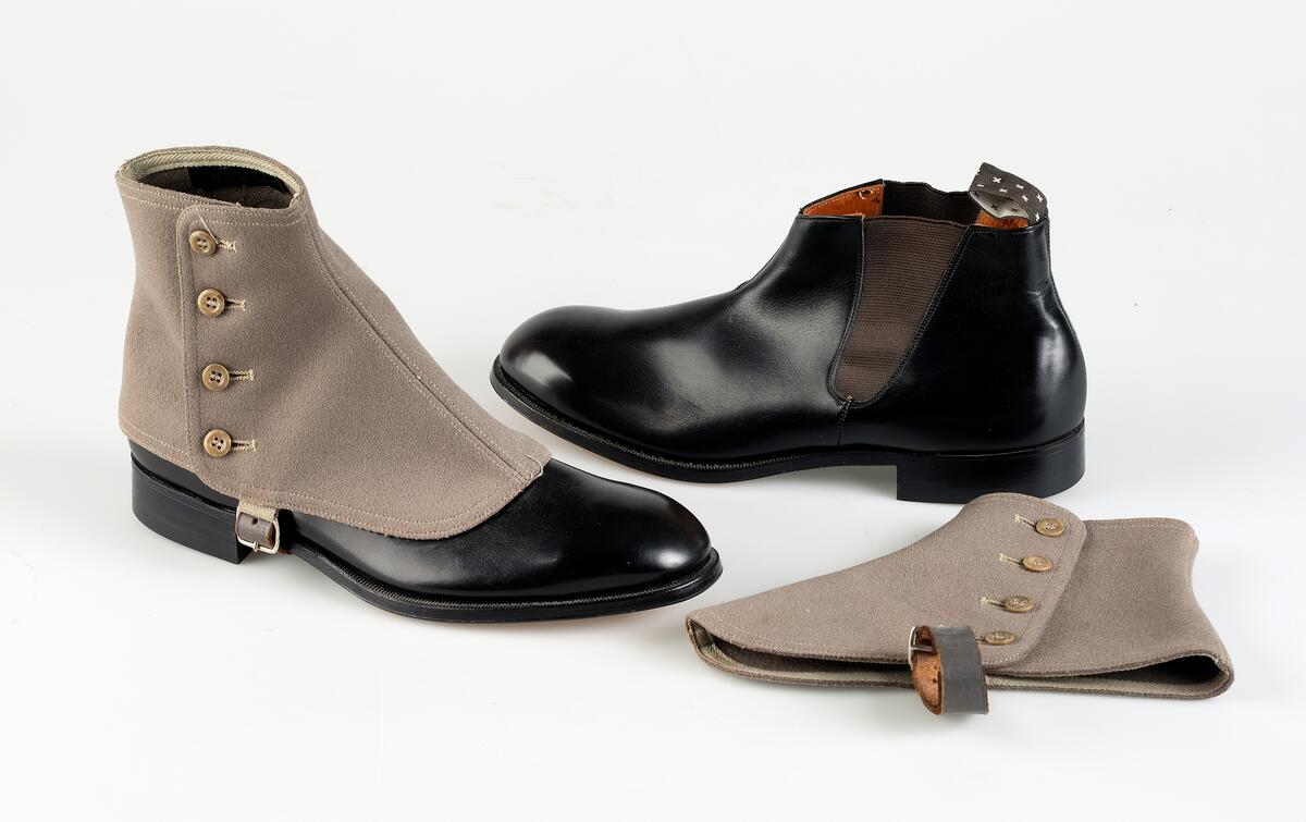 Herrsko, svart skinn av typen "boots" med lågt skaft med sydda sidoresårer. Lädersula och gummiklack. Tillverkare Hästen, Uppsala. Storlek 6½ A, klacken av märket Elg, H-17.Tillhörande damasker av grått kläde, av märket Percival SDE, storlek 42. Knäpps med fyra knappar och skinnrem, med metallspänne, under foten.