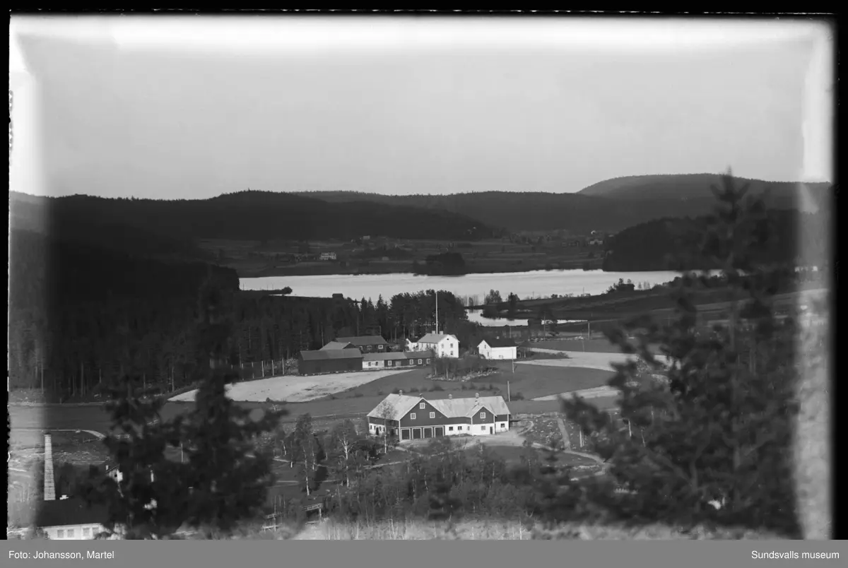 Vy från Tomtaberget mot Sörfors bruksområde. I förgrunden Marmen, till vänster massafabriken, centralt i bilden bruksladugården "Stallet" och där bakom gården Brännsvedjan. Längre bort syns sjön Vikarn och byn Skedvik.