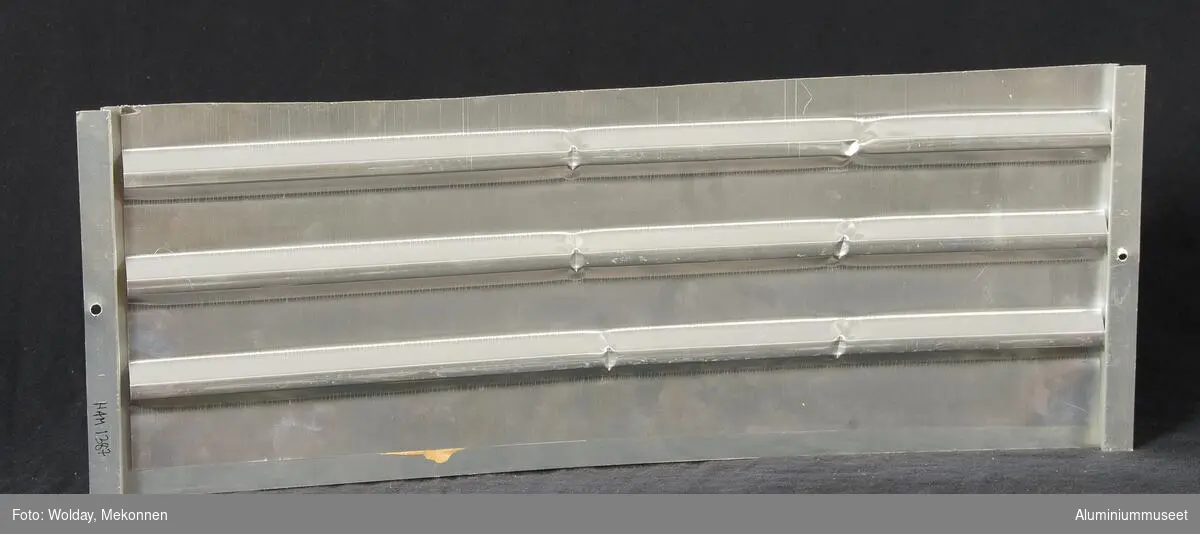 Prøve på veggplate. To deler sammenlimt; forside og bakside. Bakside ikke farget