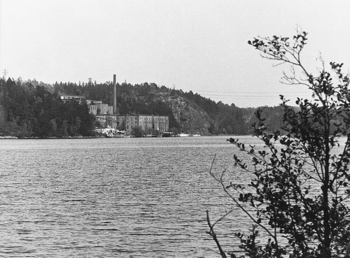 Tollare pappersbruk. Bruket - grundat av Johan Alfred Hedenström och sonen Daniel - var i drift åren 1922-1964. Fabriken revs år 2011 för att lämna plats åt ett bostadsområde.  I förgrunden Lännerstaviken. Foto 1975.