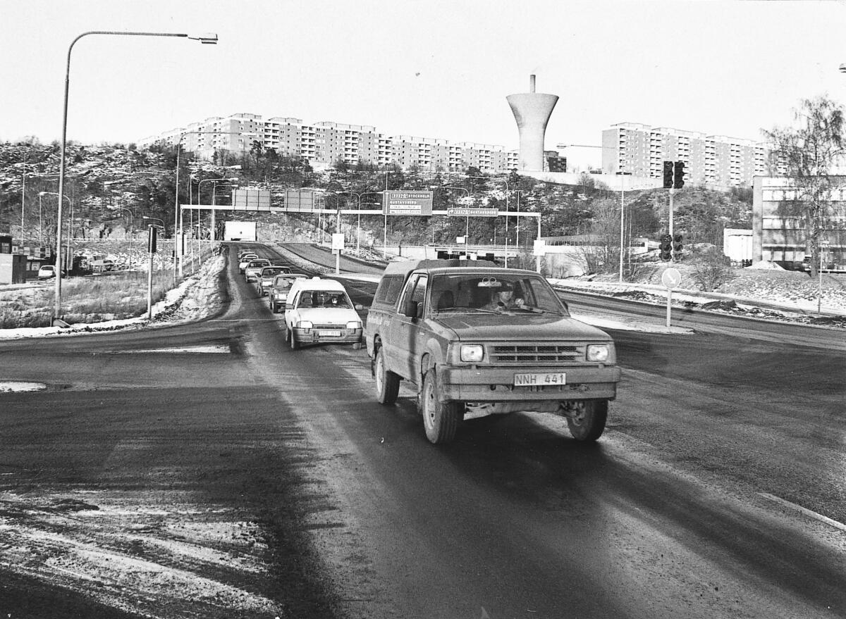Projekteringen av Henriksdalsringen - byggnaderna i bakgrunden - började redan på 1940-talet, men bygget försenades av oklarheter kring vägtrafiken på Västra Sicklaön. Inte förrän Värmdöledens sträckning fastställts kunde man börja bygga i slutet av 1960-talet. Foto 1990.