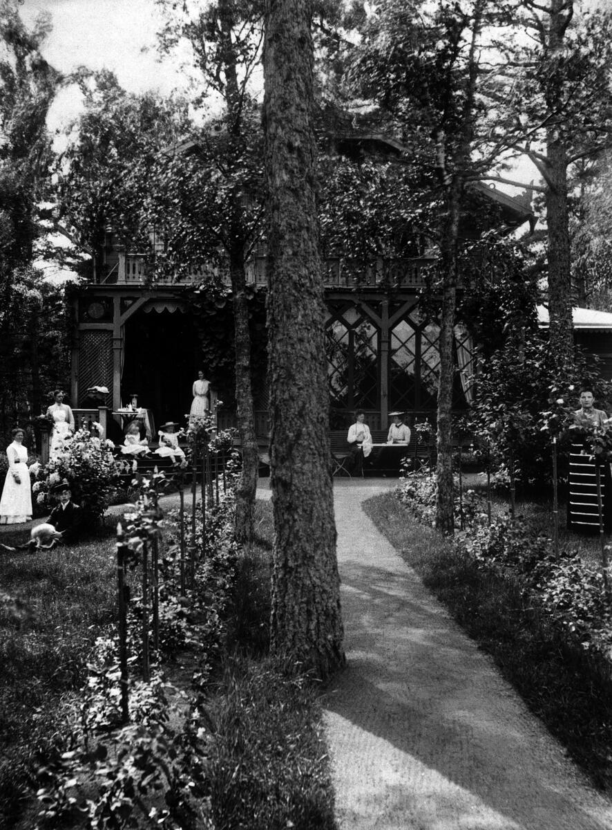 Villa Berga på Tegelön. Sommarvillan - uppförd på 1880-talet - hyrdes av Carl Berglind, som var ägare till Hotell Rydberg vid Gustav Adolfs Torg i Stockholm. På bilden har han samlat familj, släkt, tjänstefolk och trädgårdskulla för fotografering. Foto början av 1900-talet.