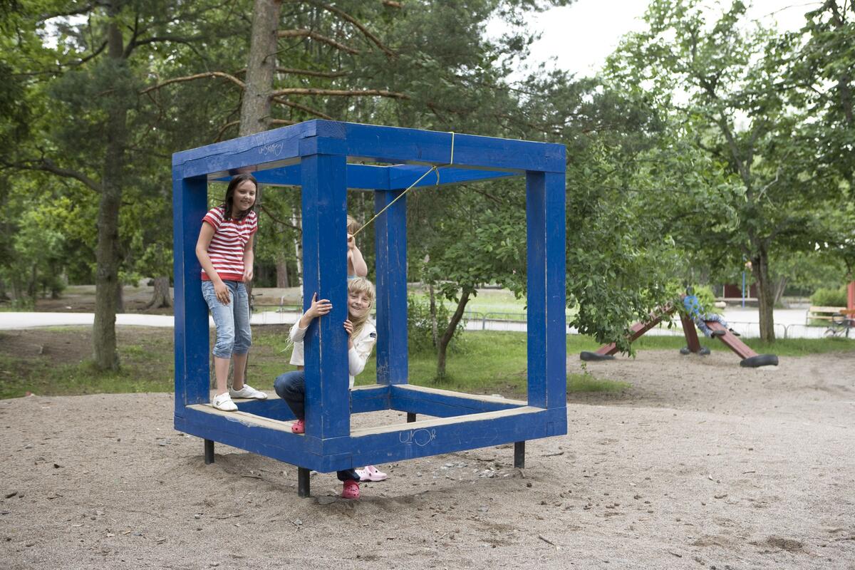 Lekskulpturerna. kub och pyramidtriangel vid Myrsjöskolan och Rödmyrans förskola. Från vänster i kuben: Ellen Bandman, Jessica Niederhauser och Emelie Kamping. Skulptur från 2000 av Gun Lindblad. Foto 2007.