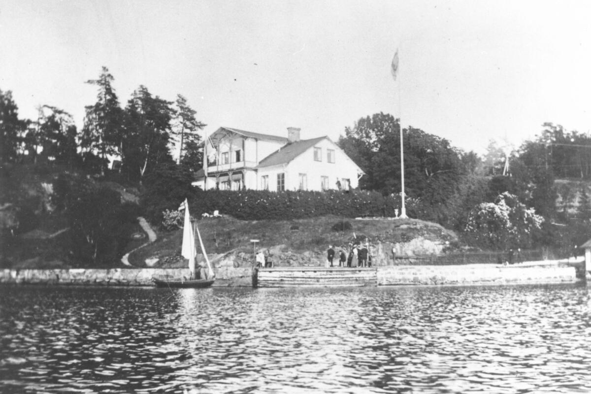 Klintens timrade ångbåtsbrygga i Björknäs och Montelius villa Klinten. Byggnaden uppfördes 1833 av Wermdö Brobyggnads Bolag. Foto ca 1905