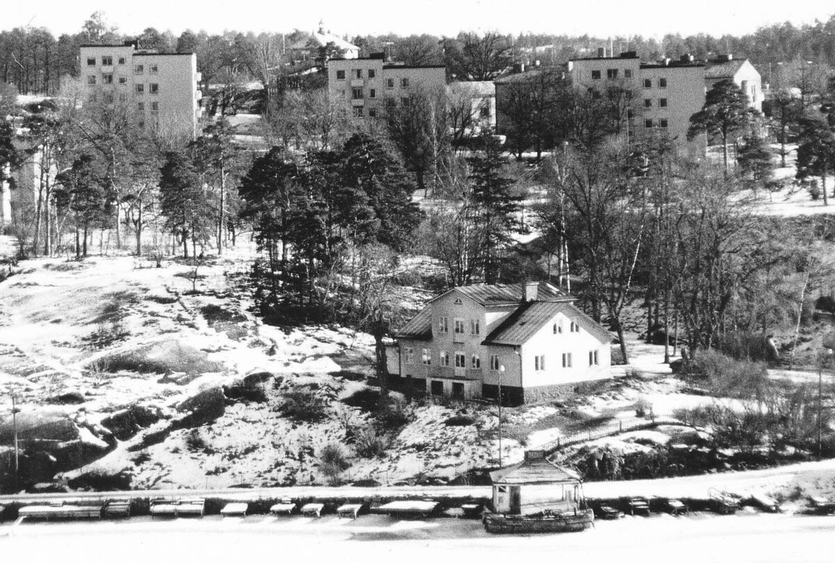 Montelius villa belägen på berget ovanför Klintens brygga. Den idag bevarade villan uppfördes 1833 av Wermdö Brobyggnads Bolag. I bakgrunden ses punkthusen på Centralvägen, som byggdes 1958. Foto 1980.