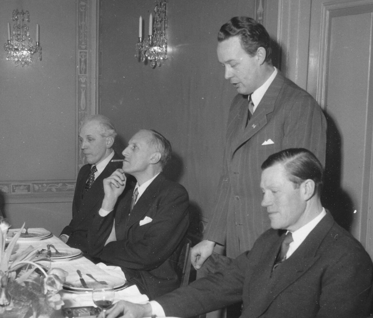 Invigningen av den nyuppförda och moderniserade Henriksdalskrossen i Lugnet den 3 februari 1955. Nackas kommunalborgmästare Olle Gestblom invigningstalar. Till vänster kamrer Eklund och advokat Bengt Landahl. Närmast i bild sitter Ragnar Sellberg, verkställande direktör för Sellbergs Åkeri. Foto 1955.
