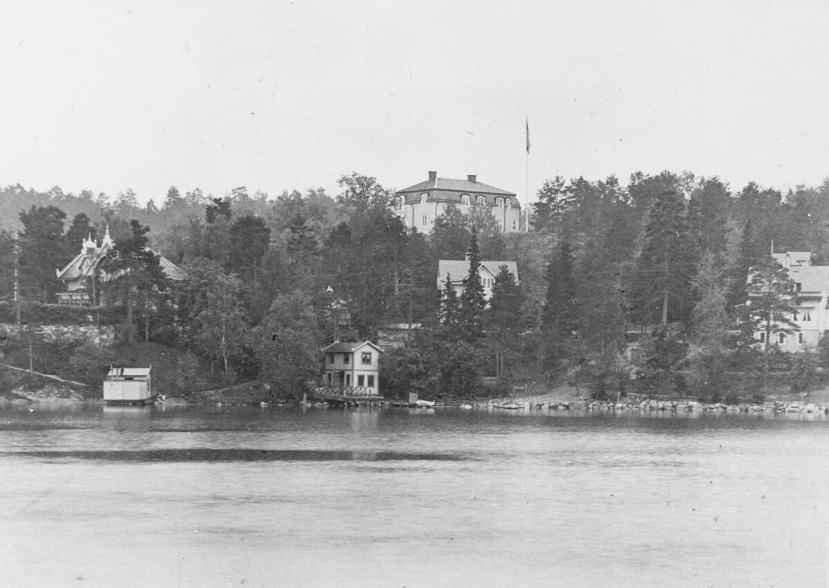Villa Dagen i området Sågtorp ses högst upp på den trädbeklädda höjden. Villan är ritad av arkitekten Evert Strokirk och uppfördes av timret från Nacka gamla kyrka som revs när den nya kyrkan  vid Järla byggdes 1892. Längst till vänster skymtar en del av häradshövding H. af Trolles Ekviken, och strax nedanför Villa Dagen syns Stensbro. Vykort ca 1900.