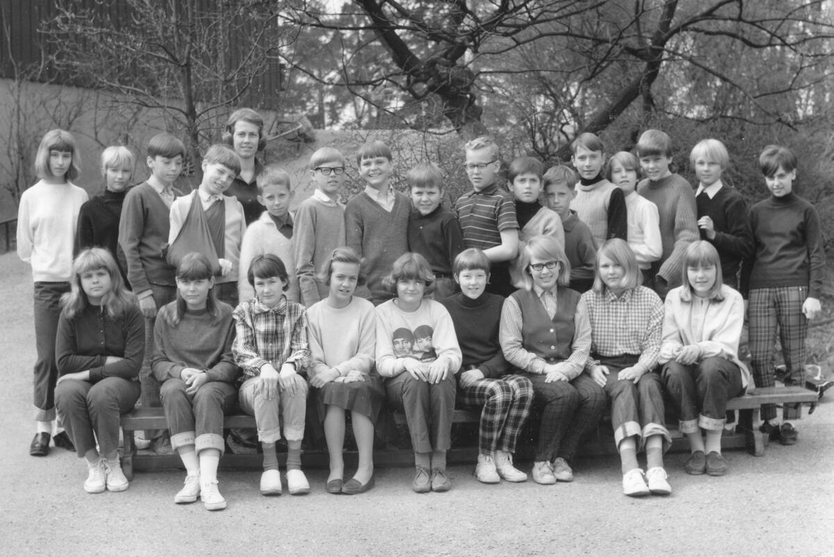 Skolklass från Ektorps skola på Skogsstigen 40 i Ektorp. I slutet av 1960-talet ökade behovet av ytterligare skollokaler för låg- och mellanstadiet i Skuru-/Ektorpområdet, och därmed fattades beslut om att uppföra en ny skolbyggnad. År 1970 stod skolan klar. I slutet av 2010-talet ökade återigen behovet av större skollokaler och sommaren 2023 revs skolan för att ge plats åt en ny, mycket större Ektorps skola. Foto ca 1965.