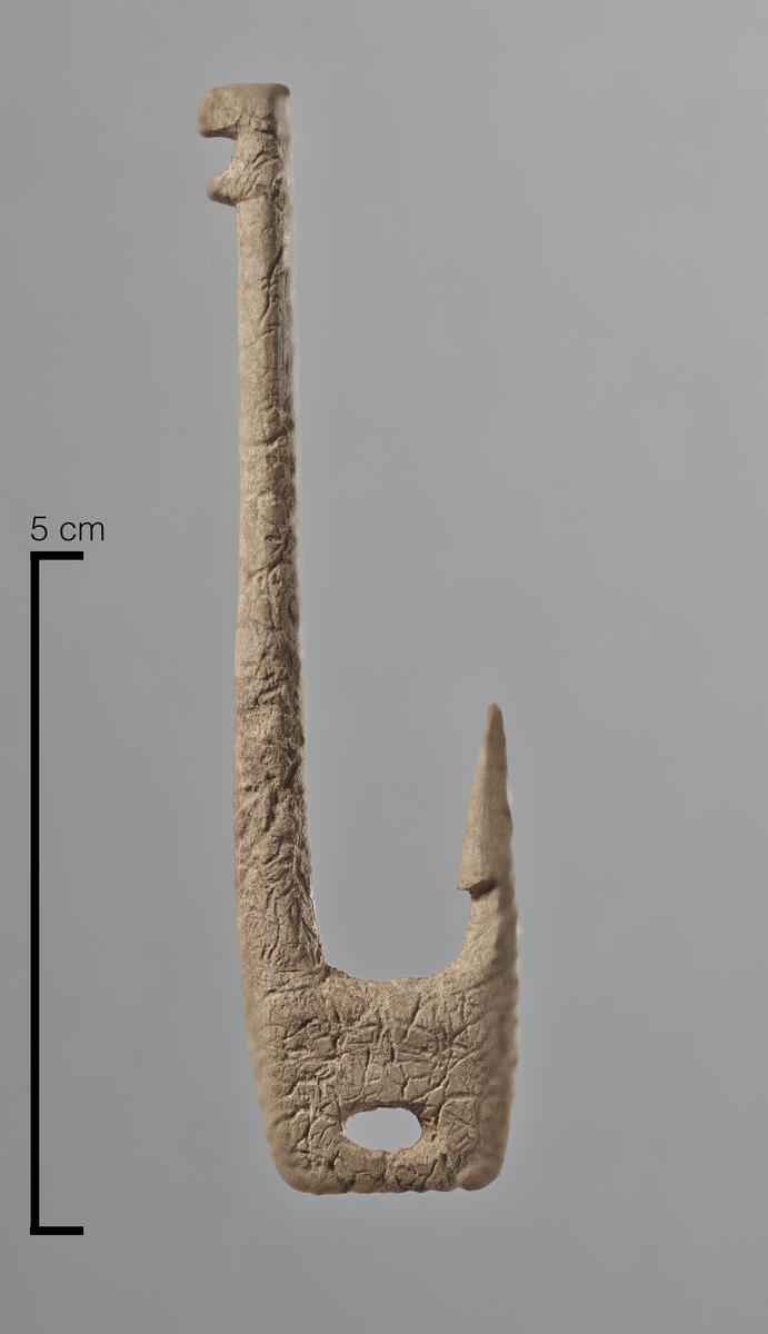 1 hel fiskekrok av bein. Brun farge. L. 8,3 cm, br. 2,2 cm (nedre del), diam. 0,5 cm. Tuft 1, rute 4x/4y (x = 4,57-64, y = 4,30-37, z = -1,91), lag 2 