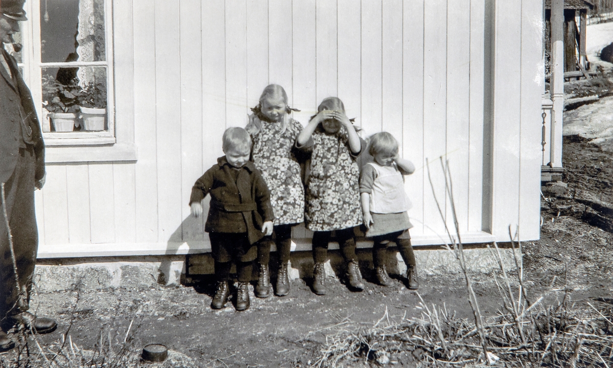 Bilde tatt i solveggen på Bruengen på Espa rundt 1923. Fra venstre: Olai Vangen, Ola Vangen, Åse Vangen - senere gift Åse Fjogstad. Ruth Vangen - senere gift Ruth Erdal. og Marit Vangen, senere gift Marit Habberstad. Fotograf Mimmi Idstrøm.