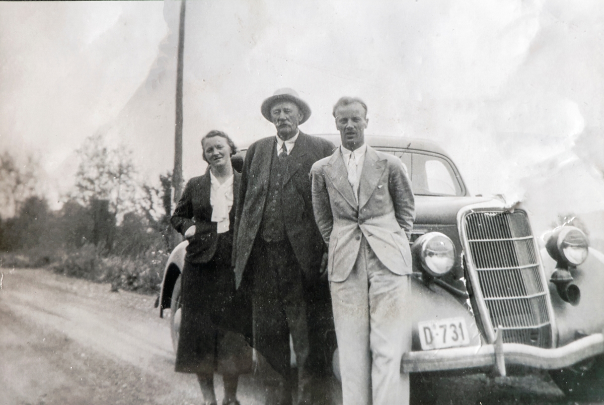 Fra venstre: Mina Dalby (02.01.1907 - 17.06.1994), Erik Thomsen (1862-1939) og Eivind Mikkelsen (16.10.1909 - 01.11.1968) Alle fra Ottestad, stående foran en bil med reg.nr: D-731
