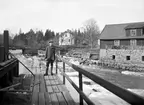 Motiv från Malfors vid mitten av 1920-talet. Från omkring förra sekelskiftet kom områdets karaktär att förändras i grunden. År 1902 etablerade Cloetta verksamhet i nya fabrikslokaler till vänster ur bilden och från 1932 uppfördes Malfors kraftstation med nödvändig reglering av Motala ströms flöde. Dessförinnan hade Malfors stora kvarn tagits ur bruk och rivits ned.