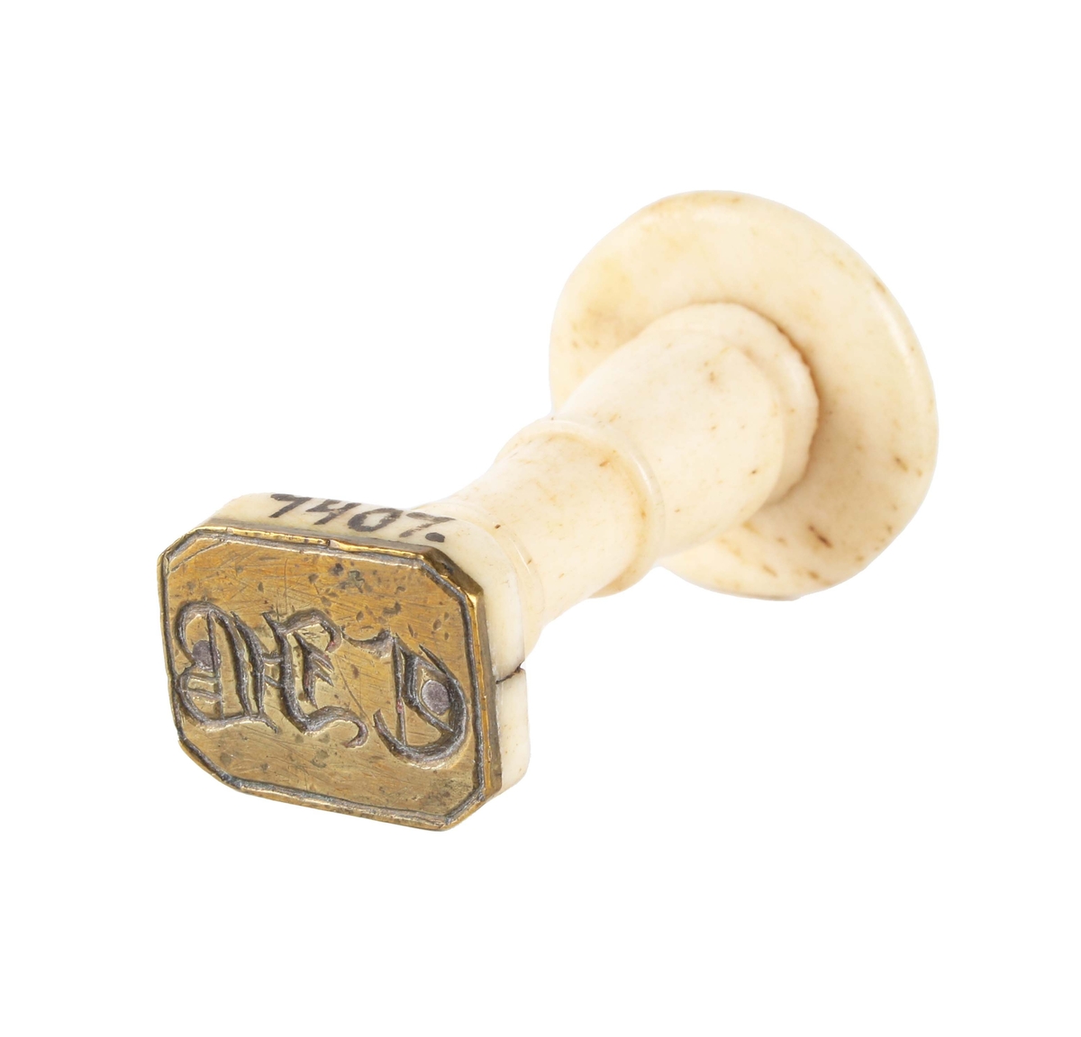 Sigillstamp. Balusterformat, svarvat, profilerat benskaft. Rektangulär mässingsplatta med fasade hörn, graverad "CJB".