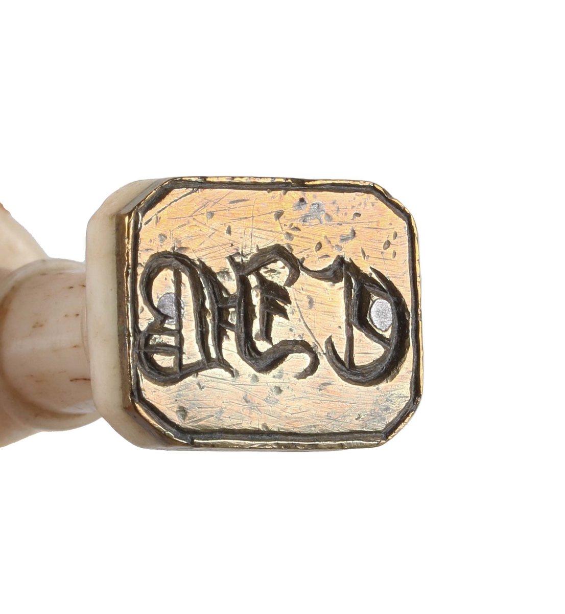 Sigillstamp. Balusterformat, svarvat, profilerat benskaft. Rektangulär mässingsplatta med fasade hörn, graverad "CJB".