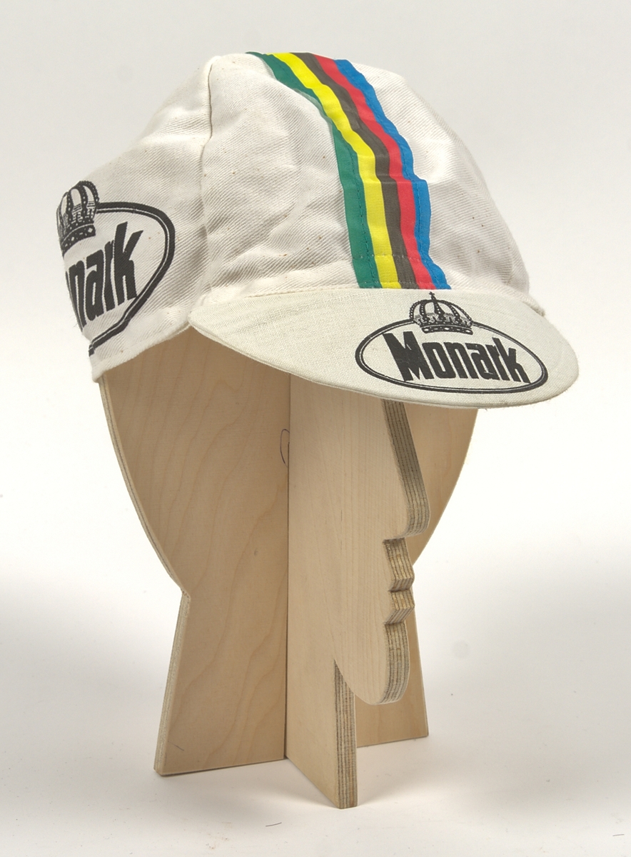 Cykeltröja i vit och lila syntet märkt: "MONARK". Tre fickor på ryggen, märkt: "MONARK" och "FALKEN DRYCKER" på både fram- och baksida. Även "Falkens" logotype på ärmarna.
Med tillhörande monarkkeps och en handske i bakfickor på tröjan.