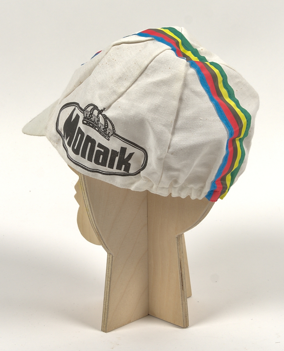 Cykeltröja i vit och lila syntet märkt: "MONARK". Tre fickor på ryggen, märkt: "MONARK" och "FALKEN DRYCKER" på både fram- och baksida. Även "Falkens" logotype på ärmarna.
Med tillhörande monarkkeps och en handske i bakfickor på tröjan.