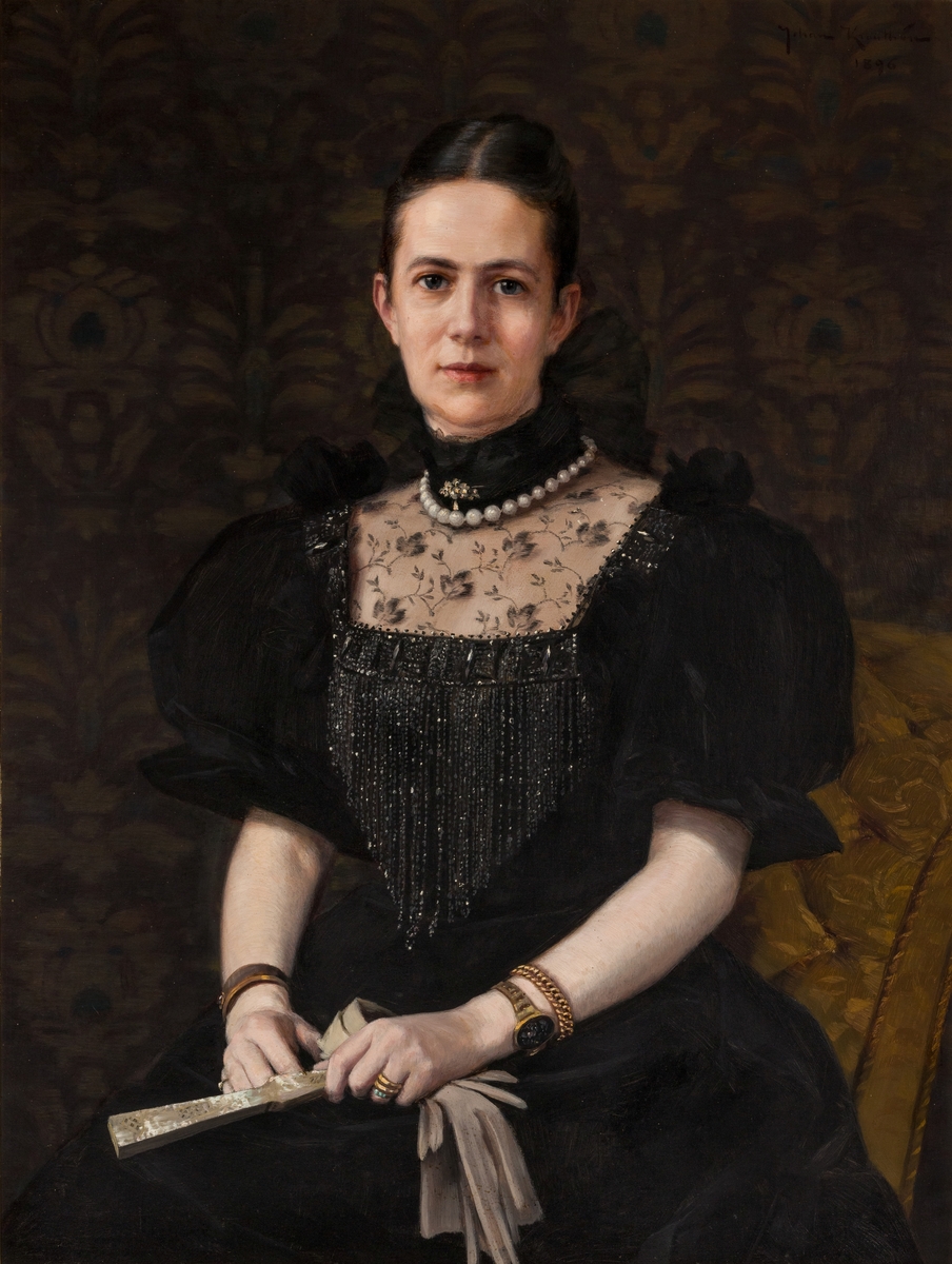 Halvfigur porträtt av Louise Lovén, svart klänning, vitt pärlhalsband, armband i guld,