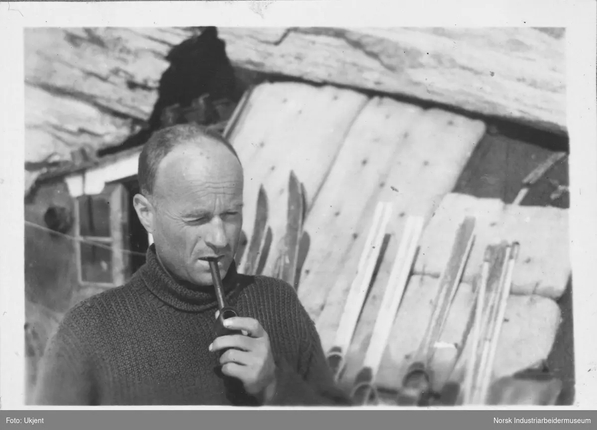 Rolf Frøland med pipa i munnen stående utenfor Fieldfarehytta.