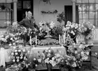 Man omgiven av blomsterarrangemang.
Fotografens ant: Maskininspektör Olsson 18/7 1936.