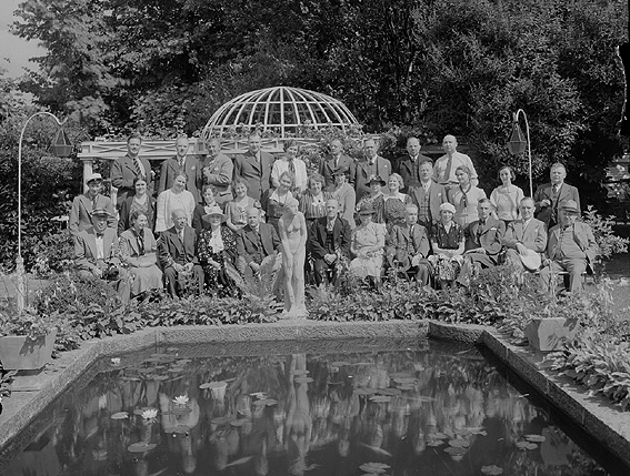 Större grupp män och kvinnor samlade vid damm i park.
Fotografens ant: Häradsskrivarekongressen 1936.