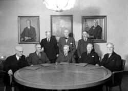 Åtta män i kostym vid bord.
Fotografens ant: Karlstads Sparb