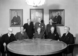 Åtta män i kostym vid bord.
Fotografens ant: Karlstads Sparb