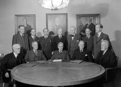 Tolv män i kostym vid bord.
Fotografens ant:Karlstads Sparba