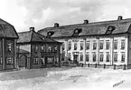 Bilden föreställer tre tvåningshus. Förmodligen Karlstad torg före 1865 .