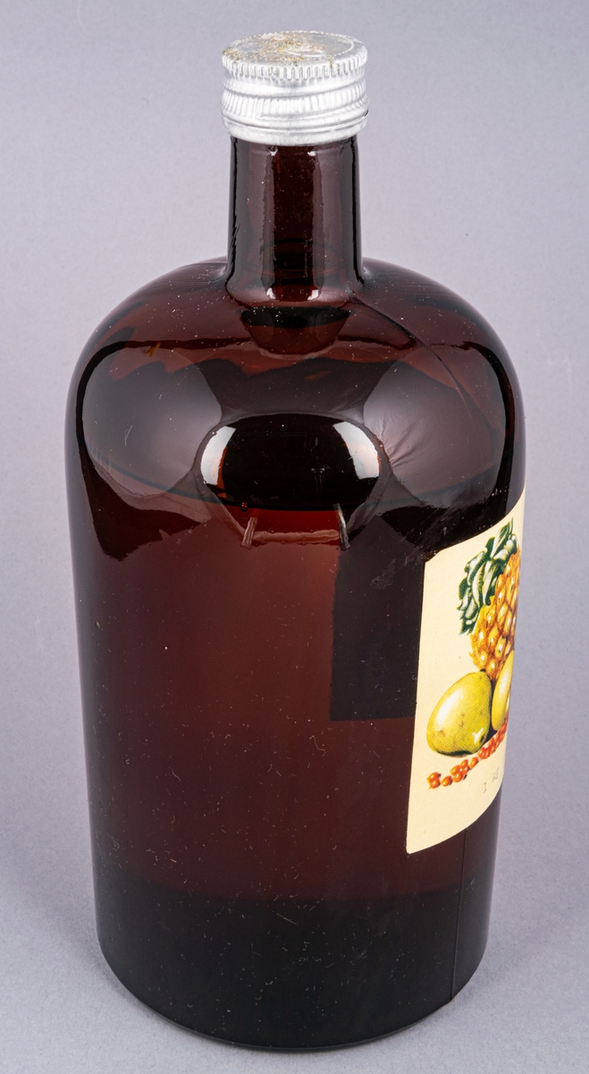 Glasflaska, brun, med skruvkork. Innehåller essens. Etikett: "Aromatic 1 kg Ahlgrens Tekniska special" samt frukter.