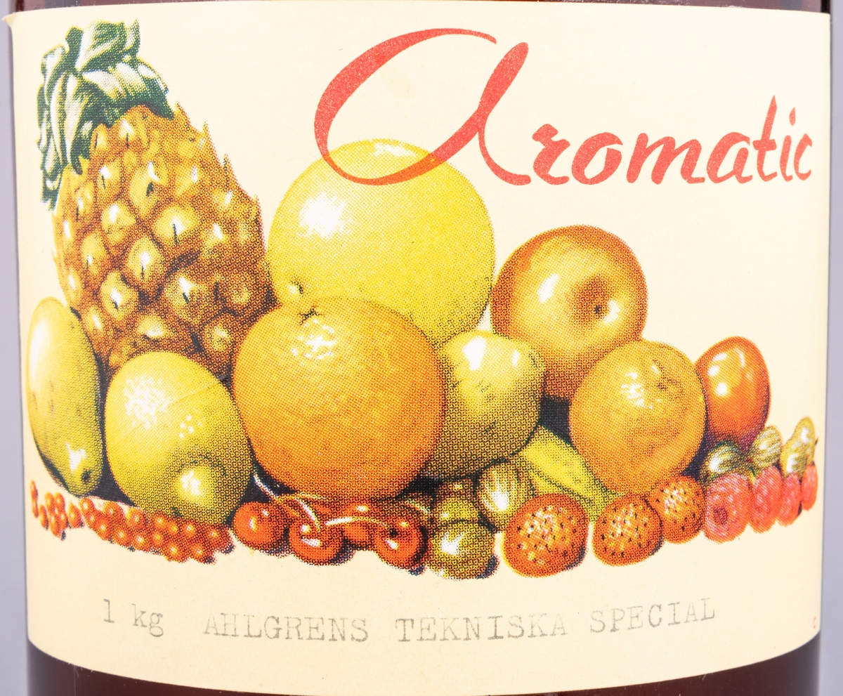 Glasflaska, brun, med skruvkork. Innehåller essens. Etikett: "Aromatic 1 kg Ahlgrens Tekniska special" samt frukter.