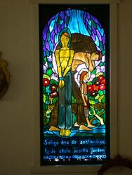 Glasmålning med motiv av saligprisningarna i Klintens kapell