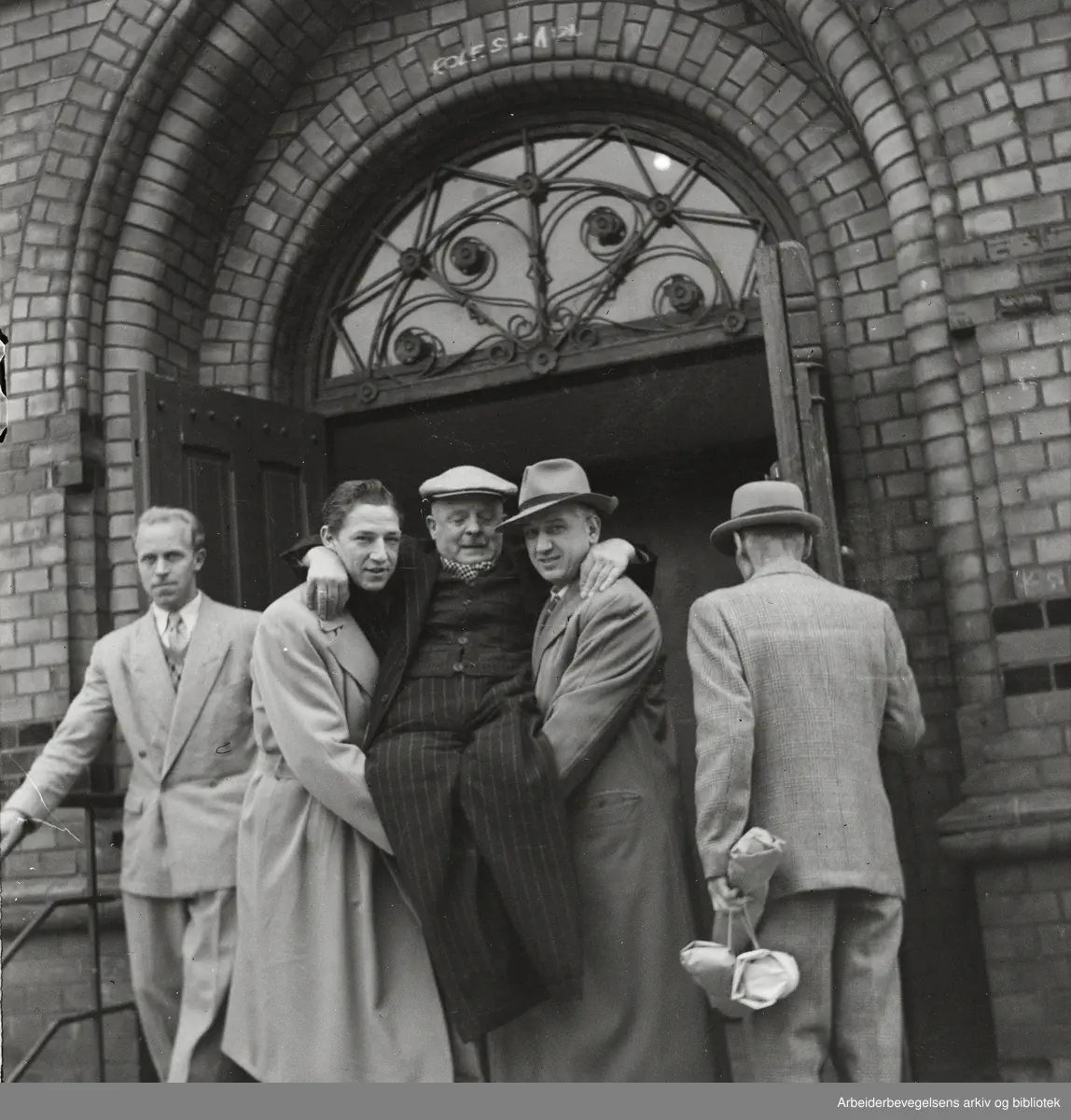 Stortingsvalget 1949. Funksjonshemmet mann hjelpes inn i valglokalet