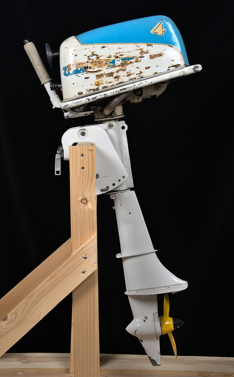 Utombordsmotor Monark Nautic 4. Encylindrig, luftkyld, tvåtaktsmotor med fyra hästkrafter. Kåpor i vit- och ljusblåfärgad metall.

Emblem och text på motorkåpans båda sidor är mycket slitna.