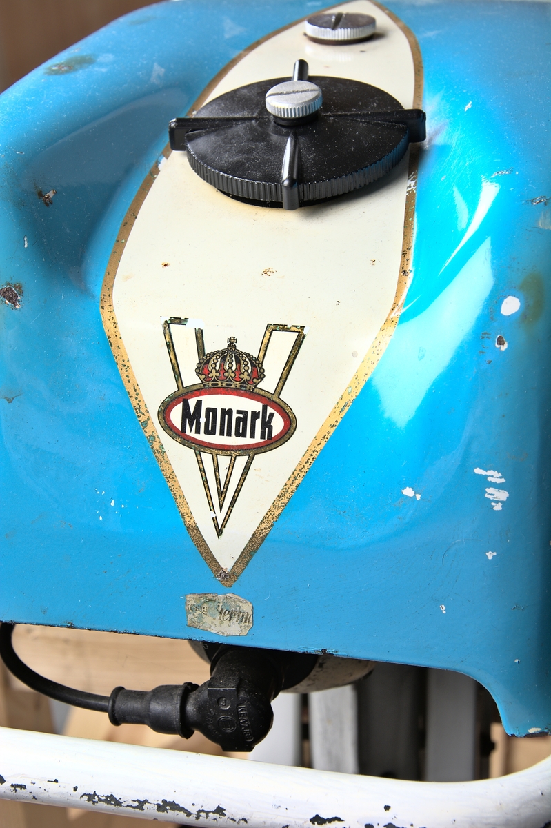 Utombordsmotor Monark Nautic 4. Encylindrig, luftkyld, tvåtaktsmotor med fyra hästkrafter. Kåpor i vit- och ljusblåfärgad metall.

Emblem och text på motorkåpans båda sidor är mycket slitna.