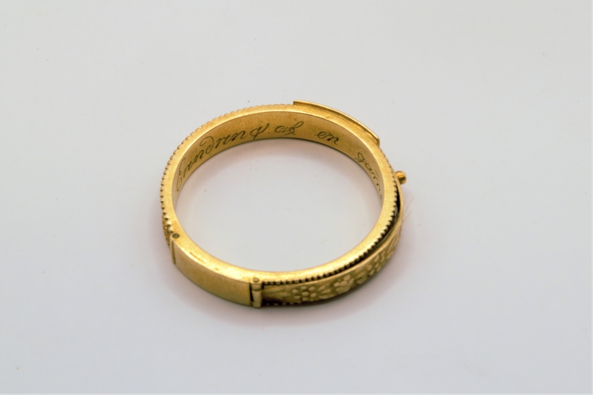 På oversiden er det to 2-cm lange lokk/avlukker med dobbelbunn. Lokkene er hengslet og forsynt med en liten knott til håndtak. Inne i den ene av avlukkene ligger en hårlokk. Begge lokkene har forsiringer av små blomster og blader.