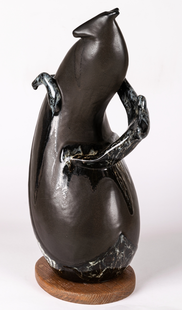 Skulptur eller figurin med titel Cirkushäst, av flintgods, gjuten och glaserad i glasyren Mangania med glasyrdetaljer i rinnande svartvitt. Bottenplatta av trä, original, signerad Lillemor. Formgiven av konstnär Lillemor Mannerheim vid Gefle Porslin, där hon arbetade som formgivare 1952-1957.
