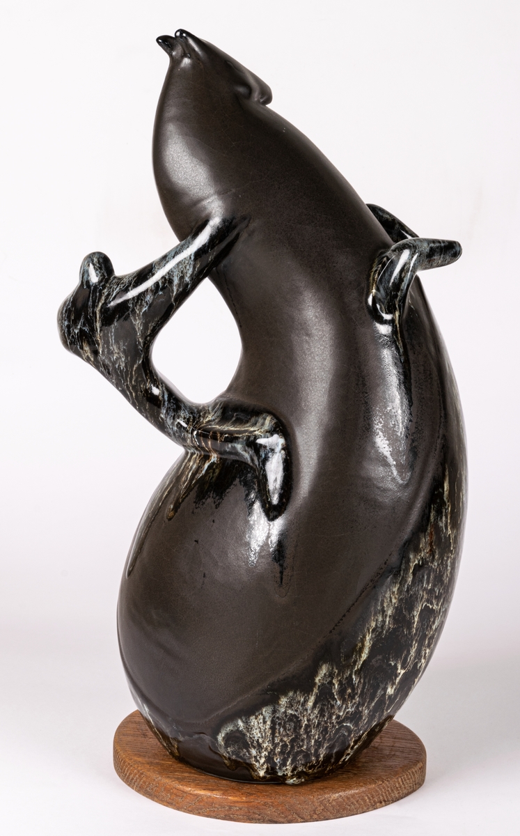 Skulptur eller figurin med titel Cirkushäst, av flintgods, gjuten och glaserad i glasyren Mangania med glasyrdetaljer i rinnande svartvitt. Bottenplatta av trä, original, signerad Lillemor. Formgiven av konstnär Lillemor Mannerheim vid Gefle Porslin, där hon arbetade som formgivare 1952-1957.