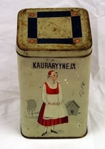 Boks. Metall. 4-sidet med kvadratisk bunn og topp. Påhengslet lokk. Beigemalt med bunadkledt dame på hver langside. Geometrisk ornamentikk på lokket. Blank metall innvendig.