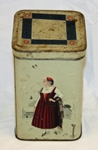 Boks. Metall. 4-sidet med kvadratisk bunn og topp. Påhengslet lokk. Beigemalt med bunadkledt dame på hver langside. Geometrisk ornamentikk på lokket. Blank metall innvendig.