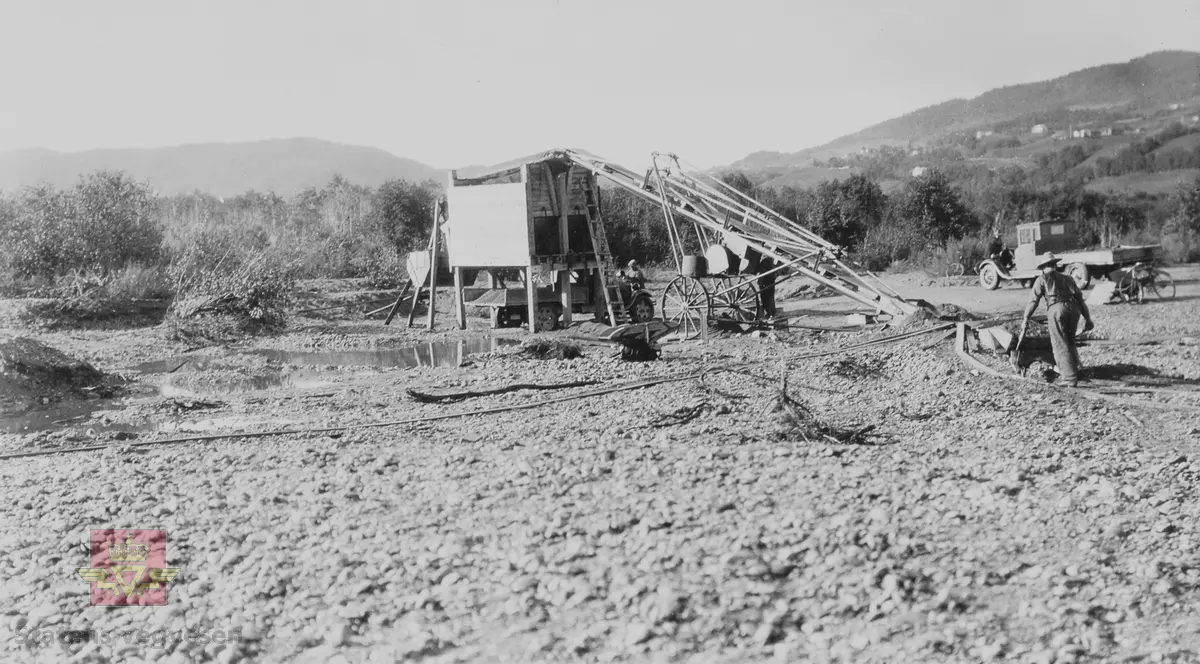 Gruslaster fra Wisbeck ved Solhus i Orkdal  oktober 1932. 
Sorteringsverk med transportbånd. Mann med trillebår. Lastebil og sykkel til høyre.